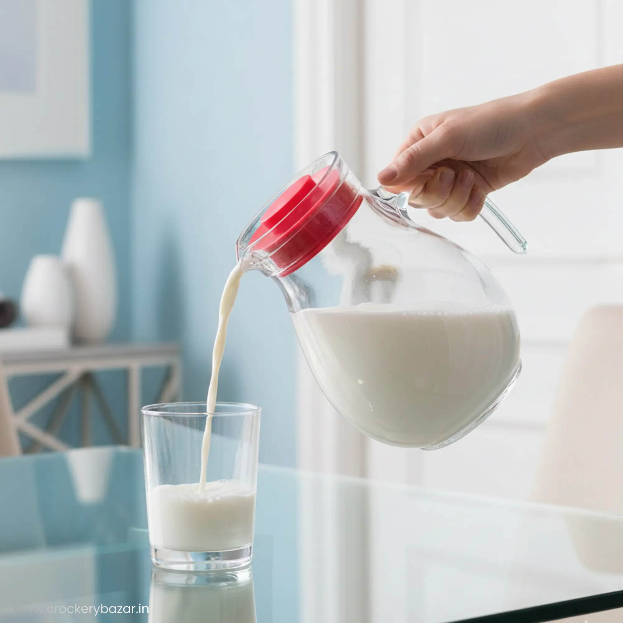 Action shot of Bormioli Rocco Sangria glass jug pouring fresh milk into a glass on a breakfast table.