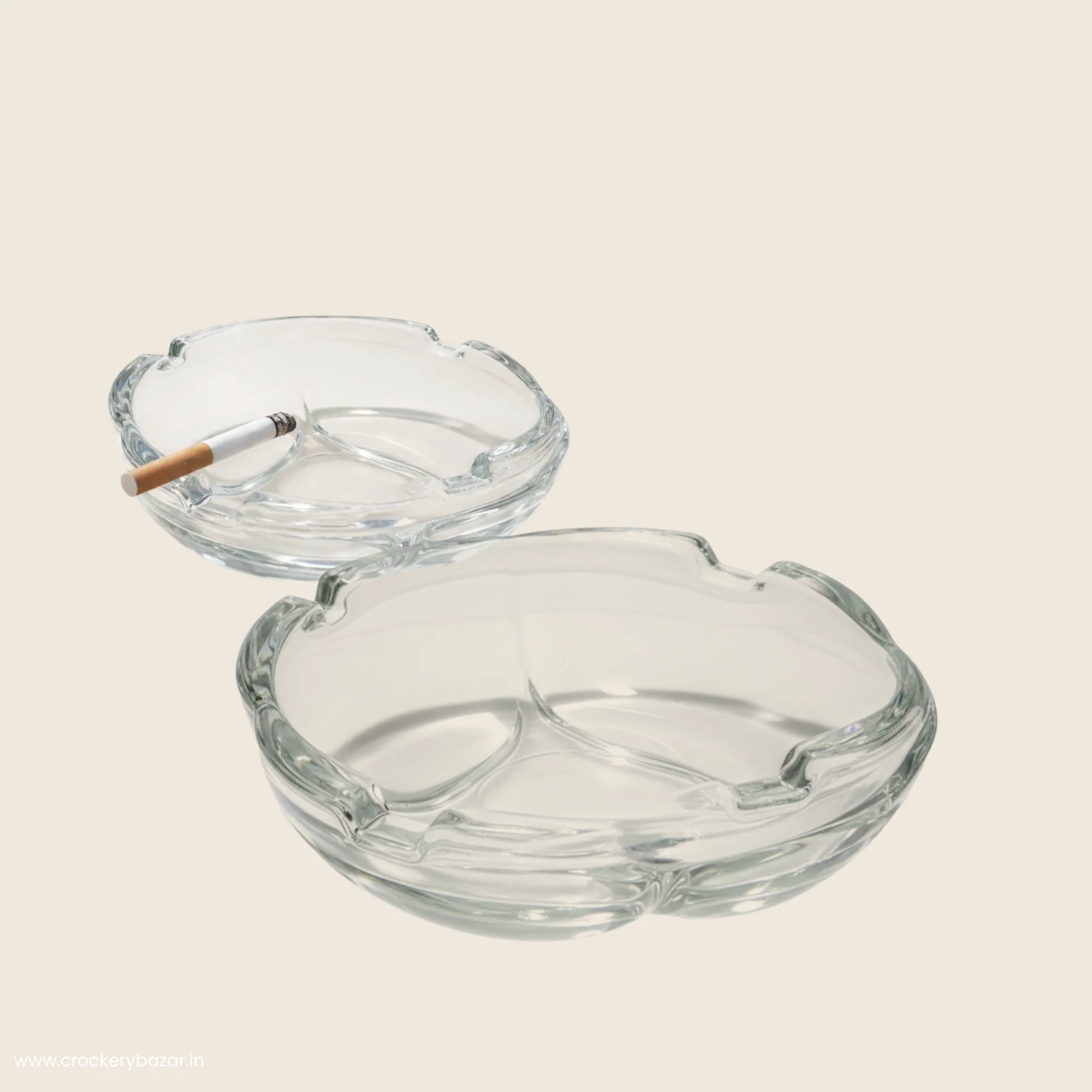 Two Bormioli Rocco Zero 11.1 cm clear glass ashtrays, one shown with a cigarette in one of its four slots.