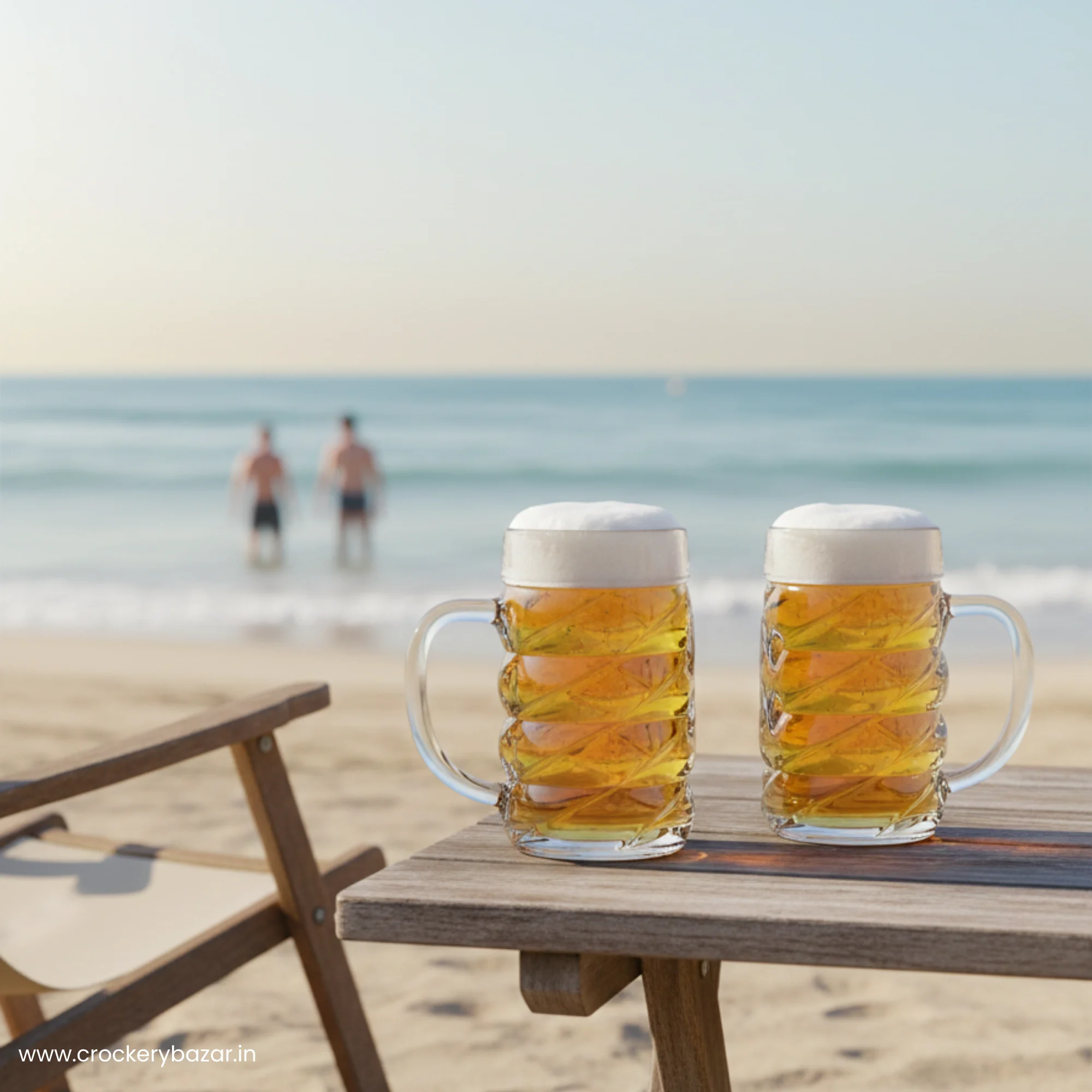 Two Ober Glas Diamond 500ml beer mugs filled with frothy lager on a wooden table at a sunny beach.
