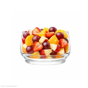 A clear and shining Nadir Figueiredo Lights glass bowl overflowing with a colorful fresh fruit salad.