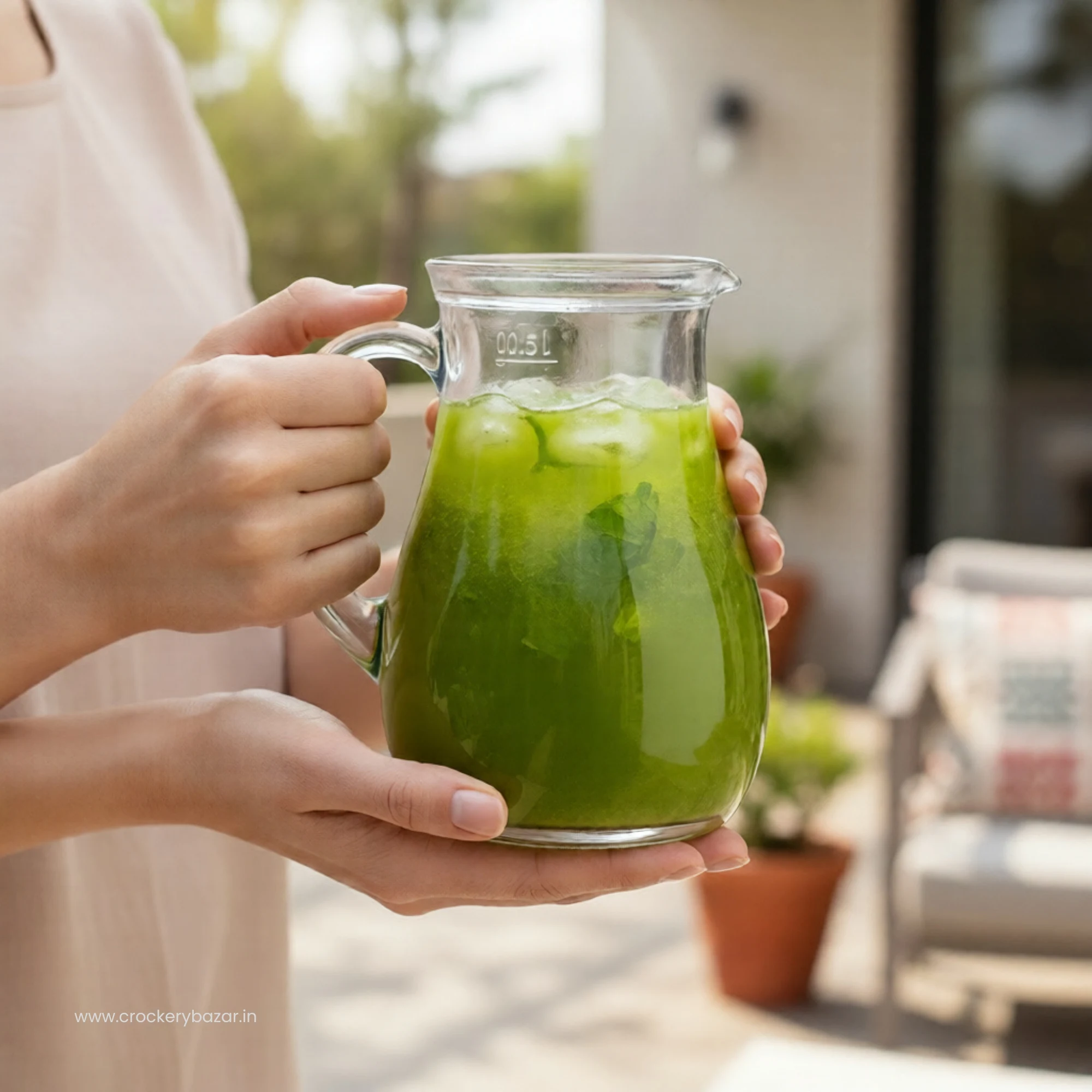Borgonovo 500ml glass jug filled with green summer beverage being held outdoors