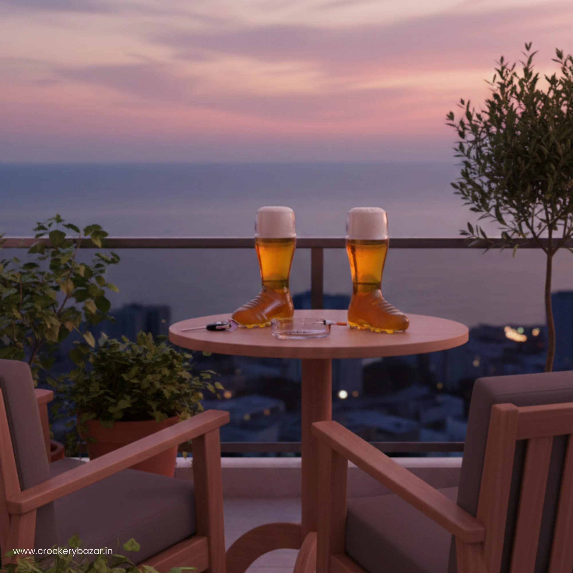 Two Borgonovo boot beer glasses on a balcony table overlooking the ocean at sunset.