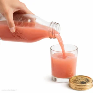 Quattro Stagioni 1L glass bottle pouring pink juice with golden lid beside glass