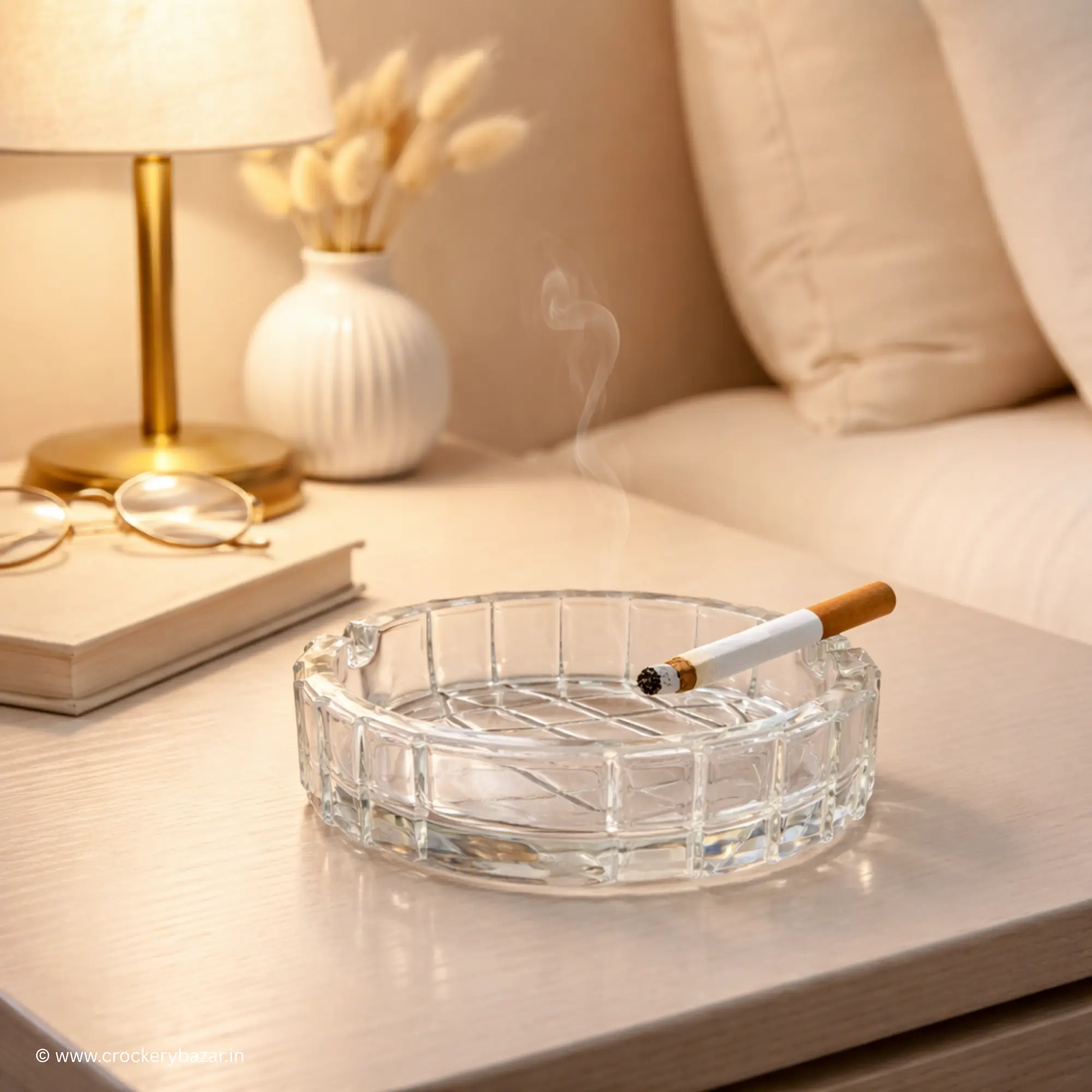 Premium large glass ashtray placed on a modern bedside table next to a lamp and spectacles, showcasing the Bormioli Rocco Duemila as a luxury cigarette ashtray for home decor.