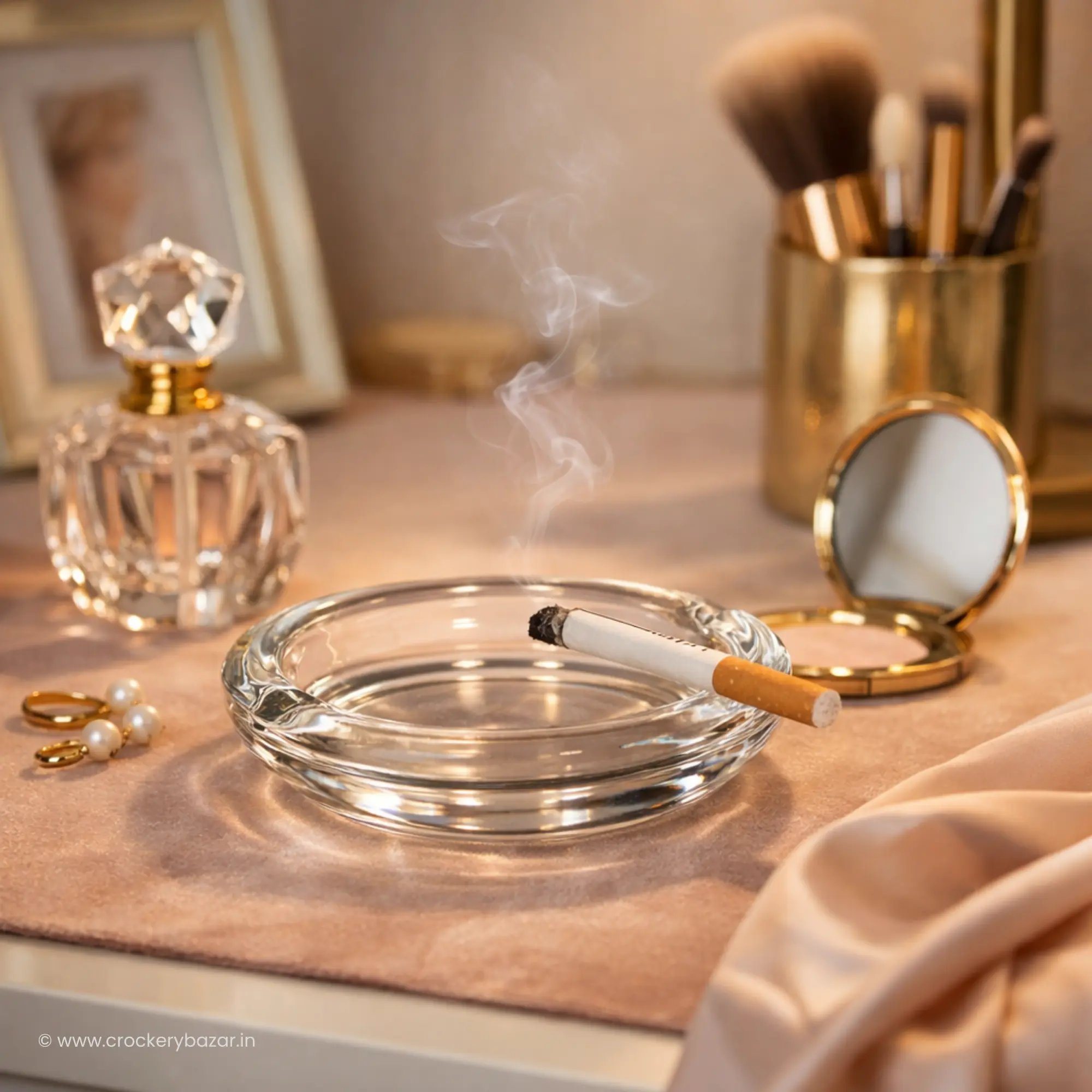Bormioli Rocco Poker small glass ashtray for smoking on an elegant vanity dressing table with gold accessories.