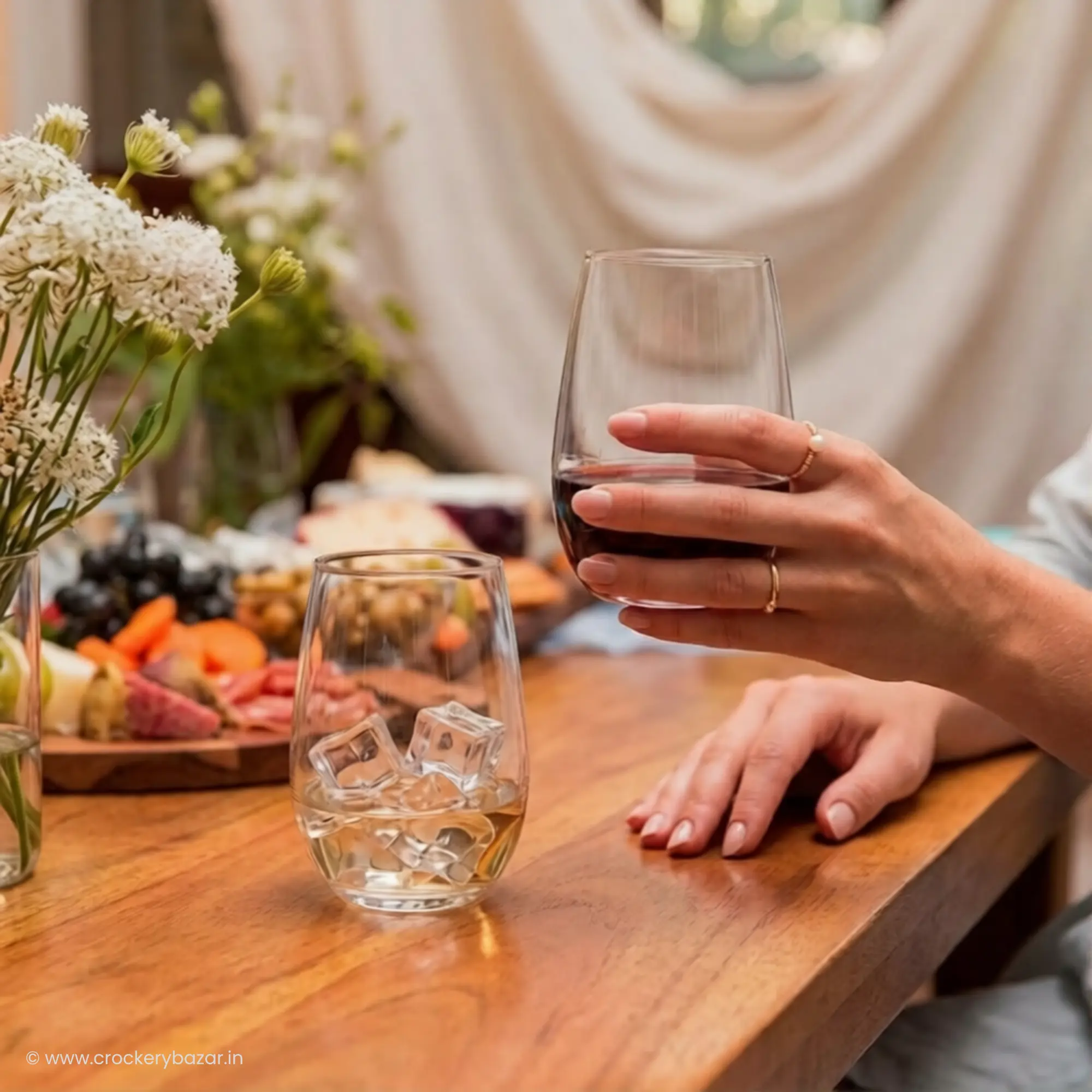 Nadir Figueiredo Dubai 460ml stylish whiskey glass held in female hand with drink and second glass on wooden table