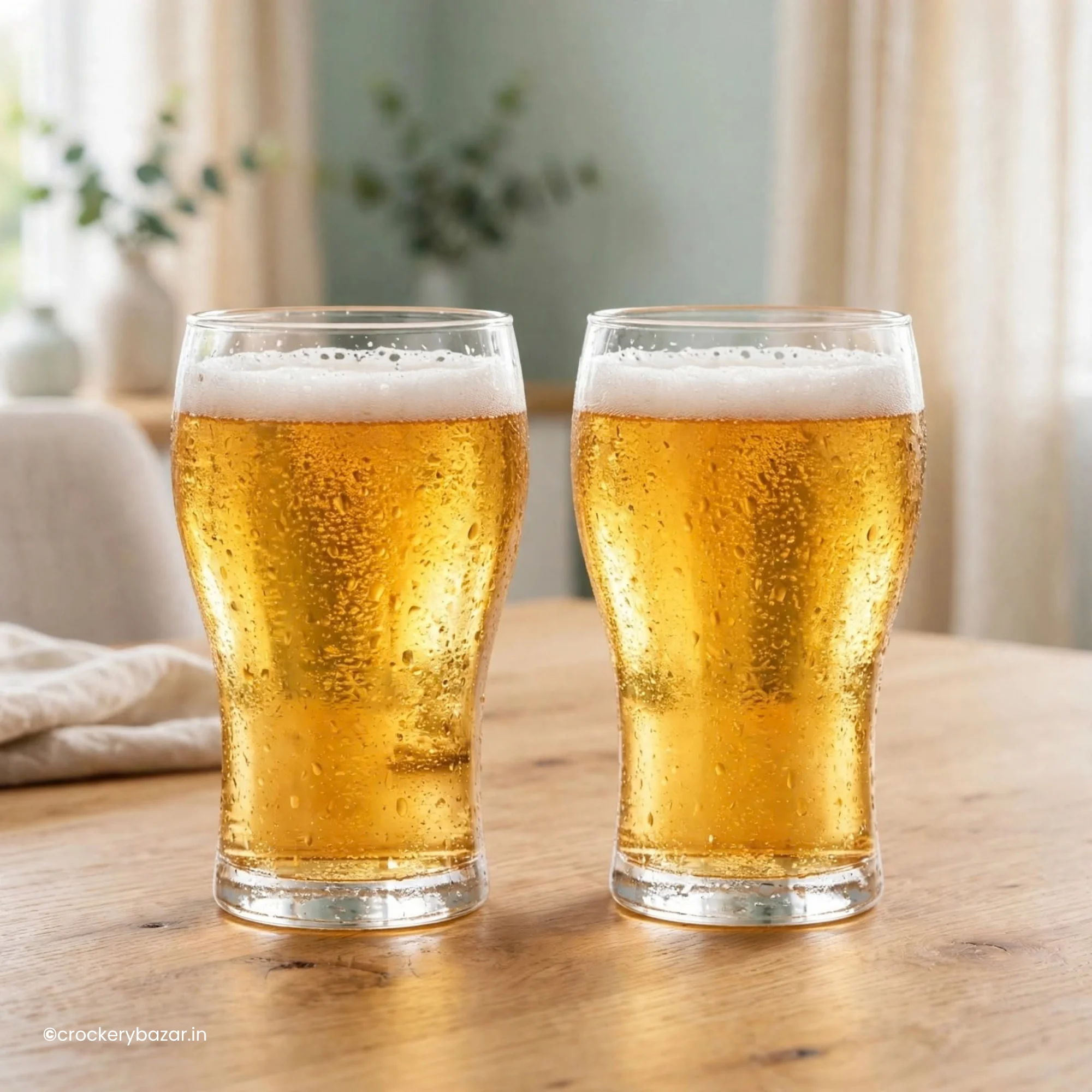 Pair of luminarc beer glasses filled with chilled golden lager on a wooden table